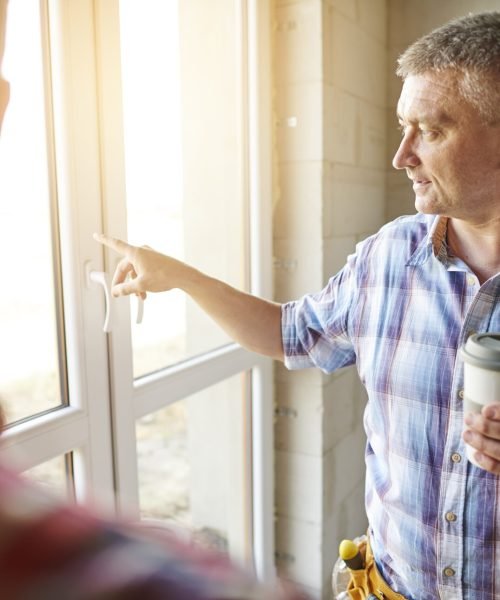 Senior carpenter is giving an advice to younger one